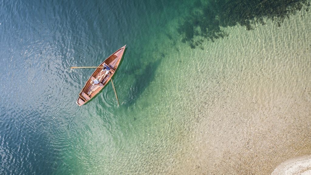 Section of Lake Millstätter See from above with rowing boat and two people